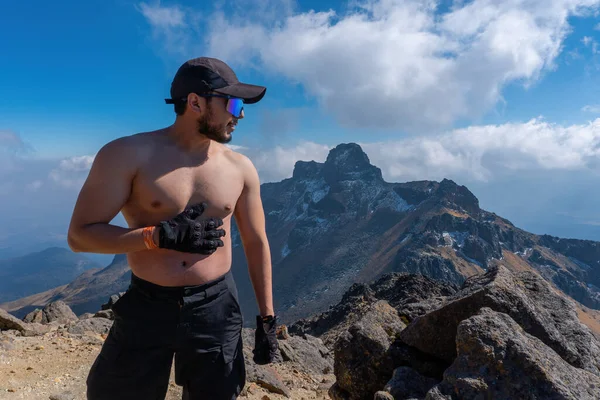 Joven sin camiseta con las manos en alto se levanta en las montañas y siente la libertad en la naturaleza. — Foto de Stock