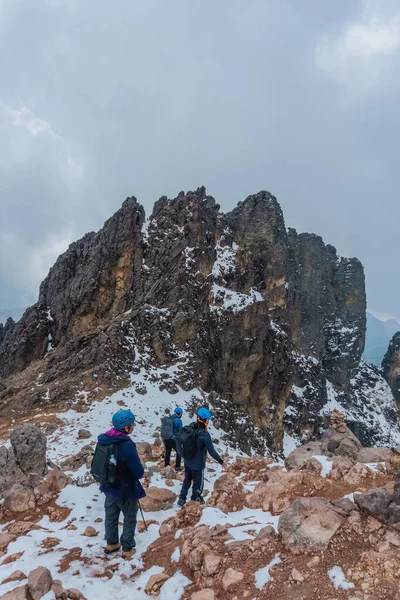 Skupina turistů stoupajících na zasněžený vrchol hory — Stock fotografie