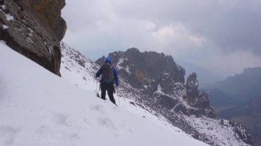 Karla kaplı dağda yürüyüş yapan biri.