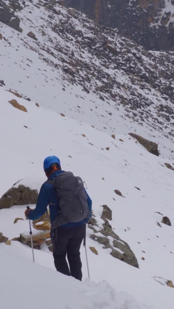 Caminhante na neve coberta montanha tiro vertical — Vídeo de Stock