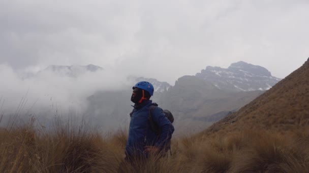 Caminhante em pé na frente de picos nevados — Vídeo de Stock