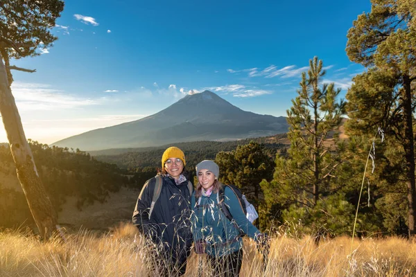 Blije vrouwelijke wandelaars met de popocatepetl vulkaan op de achtergrond — Stockfoto