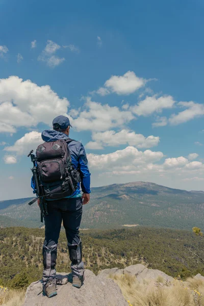 Persoon die op rots staat met uitzicht op de bergen — Stockfoto