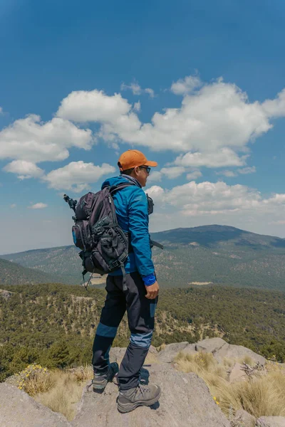 Une personne debout sur un rocher avec un point de vue de montagne — Photo