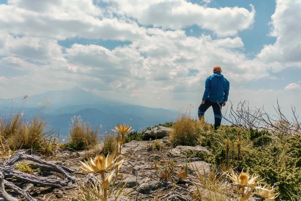 Een man staat alleen op de top van de rots — Stockfoto