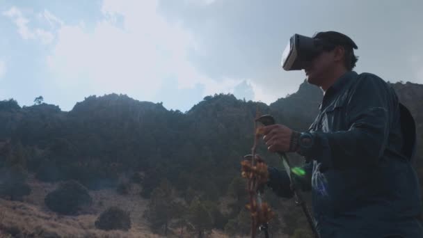 Ένας άνδρας με γυαλιά εικονικής πραγματικότητας στο βουνό — Αρχείο Βίντεο