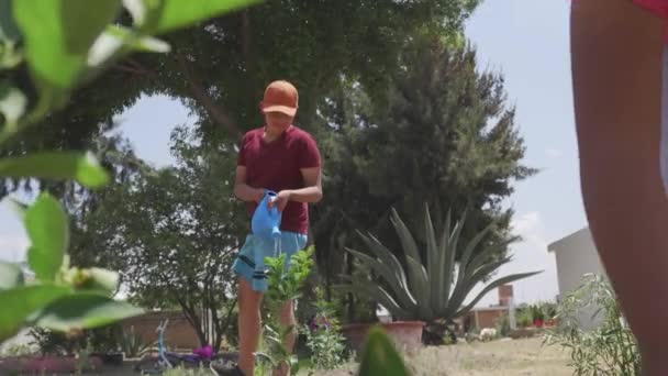 Um retrato dois sorridentes crianças segurando em suas mãos plantas no jardim — Vídeo de Stock