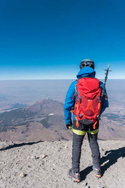 Muž na vrcholu sopky pico de orizaba a v pozadí sopky Sierra negra — Stock fotografie