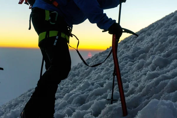 Gün doğumunda elinde buz baltasıyla dağcı silueti — Stok fotoğraf
