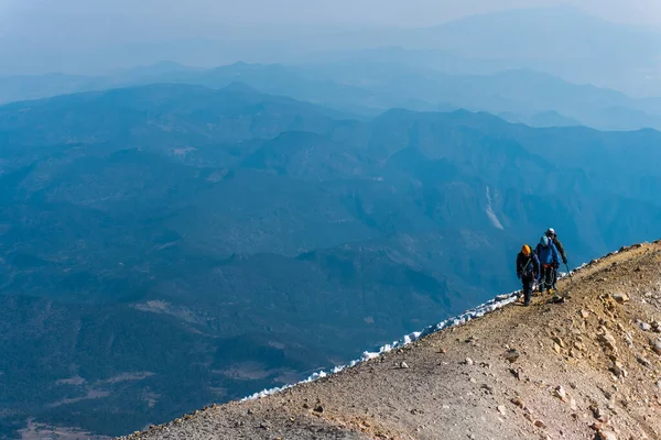 Montañistas caminando sobre el cráter del volcán — Foto de Stock