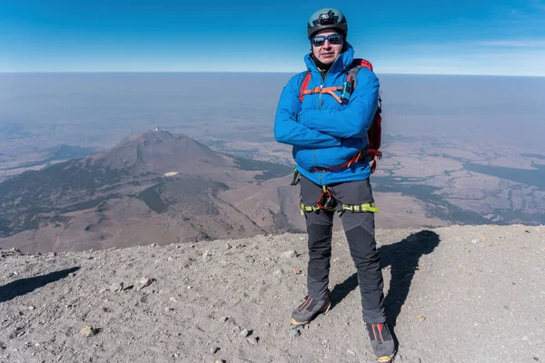 Hombre en la cima del volcán pico de orizaba y en el fondo el volcán sierra negra — Foto de Stock