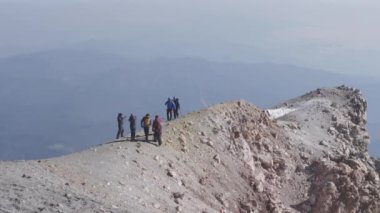 Bazı dağcılar volkanın kraterinde yürüyorlar.
