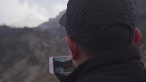 Un hombre tomando fotos de las montañas — Vídeos de Stock