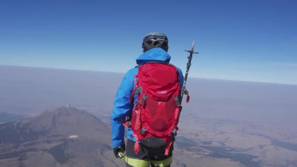 Człowiek na szczycie wulkanu Pico de Orizaba, a w tle wulkan Sierra Negra — Wideo stockowe
