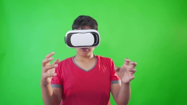 Un niño jugando juego en gafas de realidad virtual en una pantalla verde, Clave de croma. — Vídeos de Stock