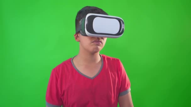 Een jongen spelen spel in virtual reality bril op een groen scherm, Chroma Key. — Stockvideo