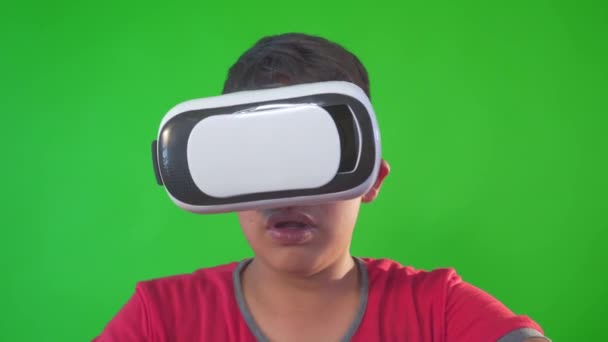 Un niño jugando juego en gafas de realidad virtual en una pantalla verde, Clave de croma. — Vídeos de Stock