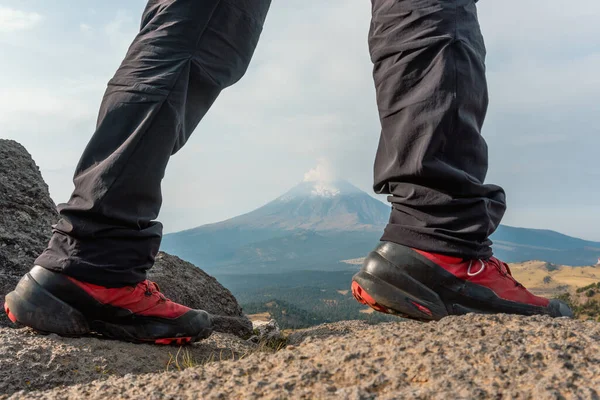Feet in trekking shoes and legs light trousers on background of the popocatepetl volcano — Zdjęcie stockowe
