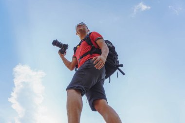 Kameralı fotoğrafçı, gün batımının fotoğrafını çekiyor.