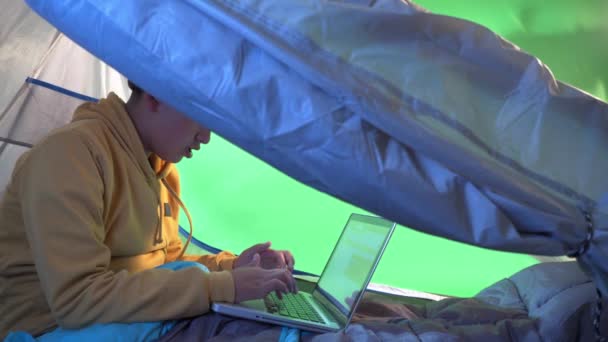 Een Jongen Spelen Met Een Laptop Een Tent Een Groene — Stockvideo