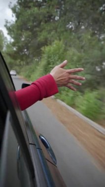 Woman hand out of the window . Concept car travel on the road trip