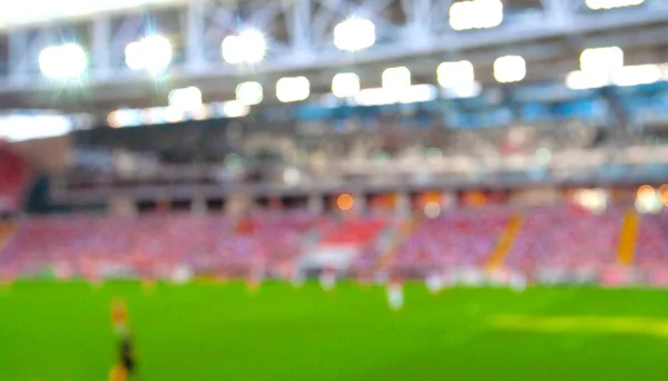 Wazig zicht op stadion in lichten en groen gras Stockfoto