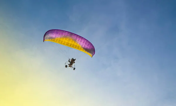 Paraglider with a motor flies in the blue sky — Stock Photo, Image