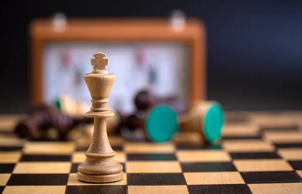 Шахові фігури на дошці і шаховий годинник на темному тлі — стокове фото