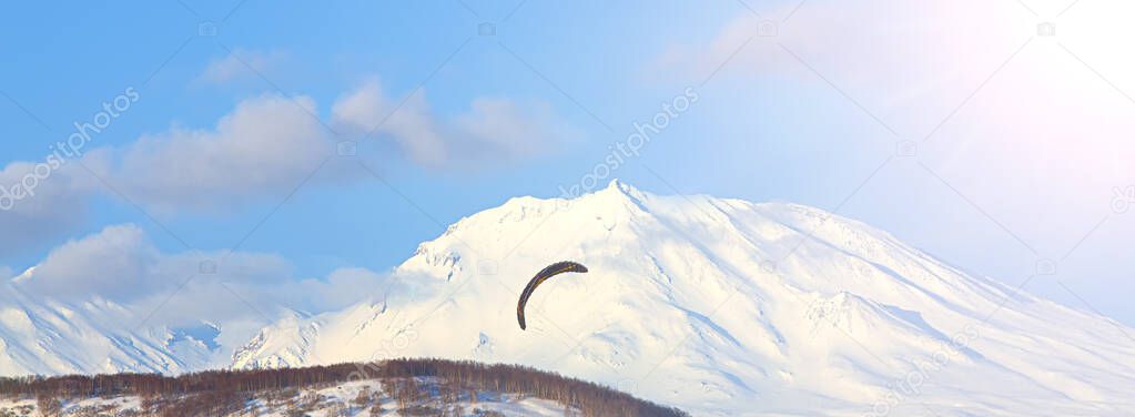 paraglider flying against the background of volcano on Kamchatka peninsula