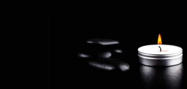 Κοντινό πλάνο από μαύρες πέτρες και κερί σε μαύρο φόντο. Έννοια τρόπου ζωής — Φωτογραφία Αρχείου