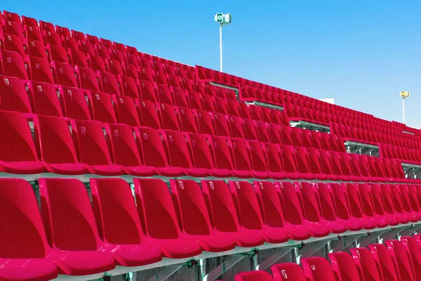 Rader av tom röd färg plast stadion sittplatser på terrassen — Stockfoto