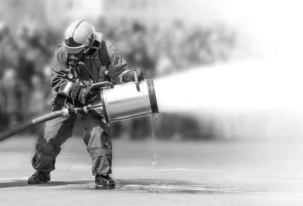 Bombeiros durante a extinção do incêndio com um equipamento especial de extinção de incêndios. — Fotografia de Stock