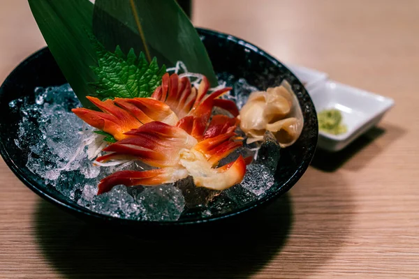 日本のスティンプソンサーフィンのハマグリやクリームピニオン テーブルの上に氷とガラスの黒いボウルと北海道の刺身 日本のヘルシーなメニューの新鮮な生魚介類 — ストック写真