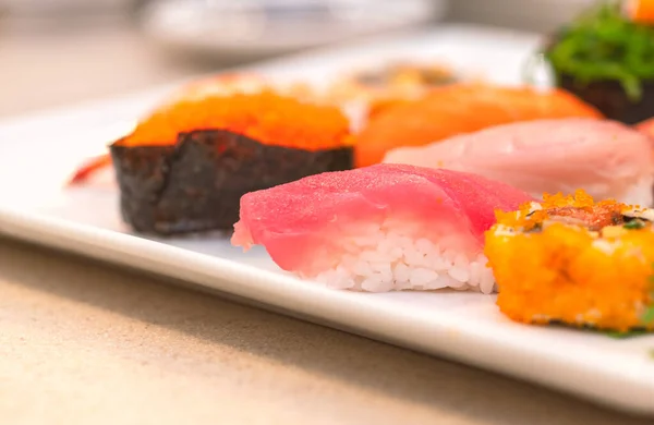 新鮮なまぐろ寿司やまぐろ寿司に焦点を当て 白いプレートに寿司を混ぜ 画像を閉じ 選択された焦点 — ストック写真