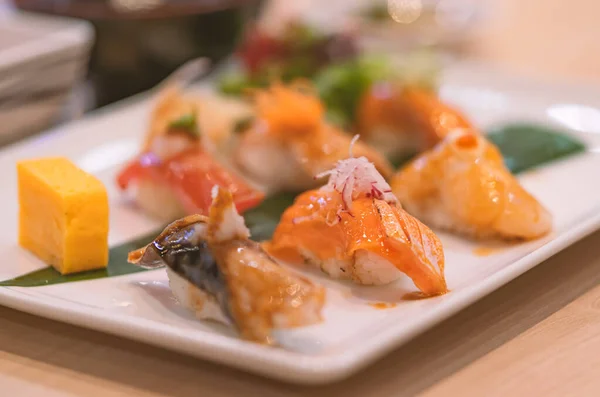 テーブルの上の白いプレートにセットされた寿司 サーモン寿司に焦点を当て 設定された寿司を閉じます 健康的な日本料理 — ストック写真