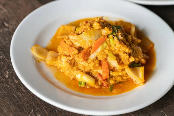 Kavrulmuş yengeç etini köri tozu ve yumurtayla kapat. Tahta masada sağlıklı deniz mahsulleri Tayland yemeği, doğal ışık..