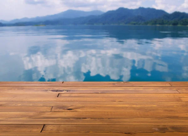 漂亮的棕色木板木桌或地板 小小的光泽表面 透视图 山水与湖泊的背景 水面上的云彩倒影 — 图库照片