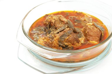 Moo Chamuang ya da Chamuang yapraklı domuz eti, tadı tatlı ve ekşi. Tayland 'ın Chanthaburi eyaletindeki ünlü yerel köri menüsü. Köri beyaz arka planda cam bir kasede..