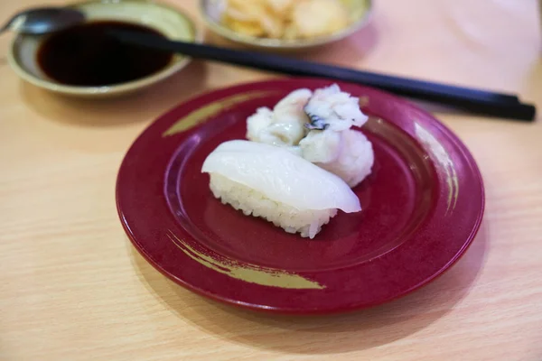 イカ握り寿司や寿司新鮮なイカ イメージ箸 醤油や醤油 生姜をぼかした赤皿の寿司イカ — ストック写真