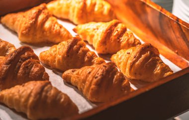 Tahta bir kutuda gevrek kruvasan. Lokantada sıcak ışık var..