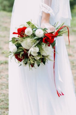 Gelinin elinde bir buket taze çiçek. Genç gelin elinde bir buket beyaz ve kırmızı çiçekle.