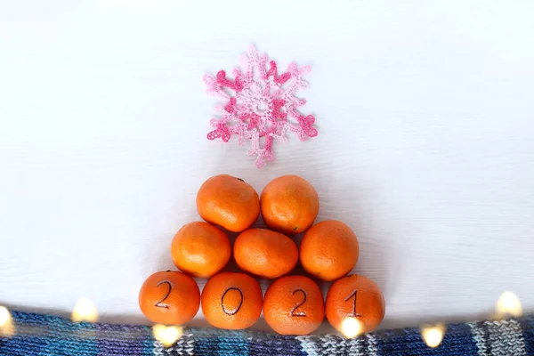 橙色水果金字塔 顶部有针织粉红色雪花 喜庆冬树的概念 — 图库照片