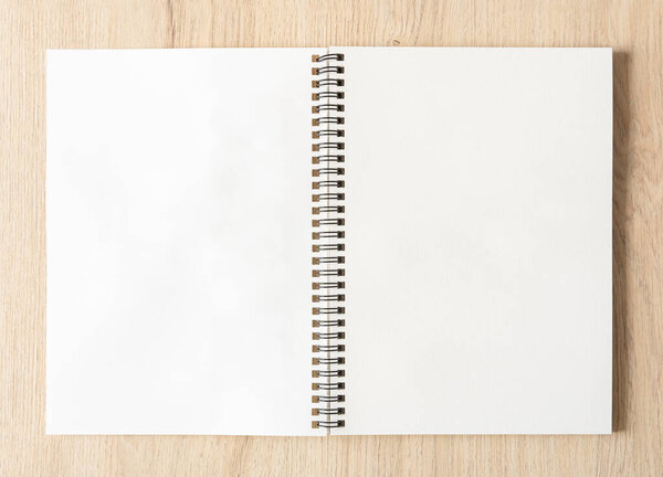 Blank spiral bound notepad mockup template with Kraft Paper cover, isolated on wood background. High resolution.