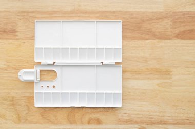 Beyaz suluboya palet. Boş suluboya tepsisi ahşap arka planda izole edilmiş. Beyaz plastik boya paleti.