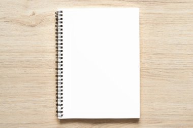 Tahta arka planda izole edilmiş, Kraft Kağıt kapaklı, boş spiral kaplı defter motifi. Yüksek çözünürlük.