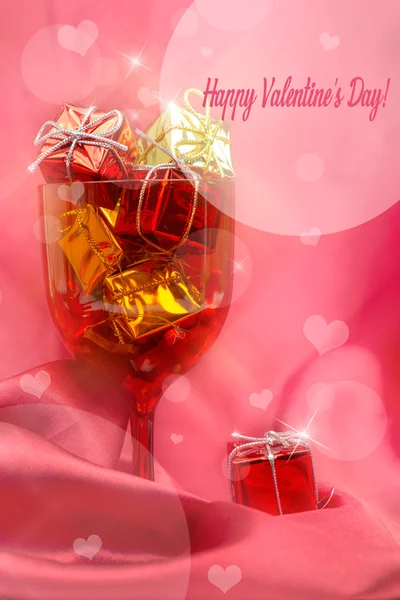 Fondo festivo rosa con vidrio, cajas de regalo y corazones —  Fotos de Stock