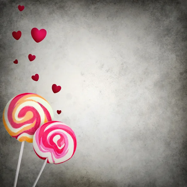 Two colorful lollipops with floating hearts on grunge background — Stock Photo, Image