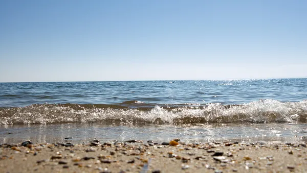 Fechar mar ondas calmas com areia e pequenas pedras molhadas — Fotografia de Stock