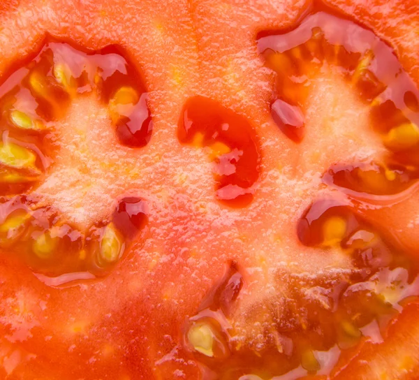 Fatia suculenta vermelha de tomate close-up — Fotografia de Stock