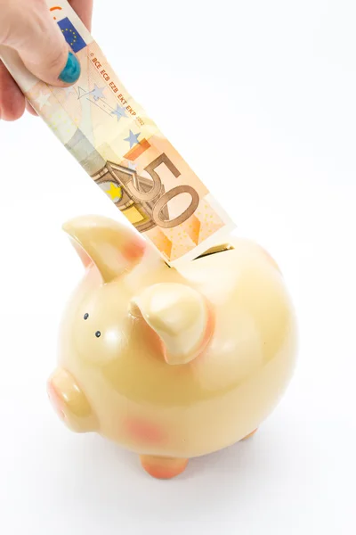 Hand storten bankbiljetten aan piggy bank geïsoleerd op wit — Stockfoto